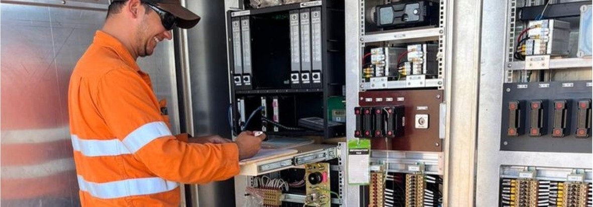 An electrician working on rail signalling control cabinets